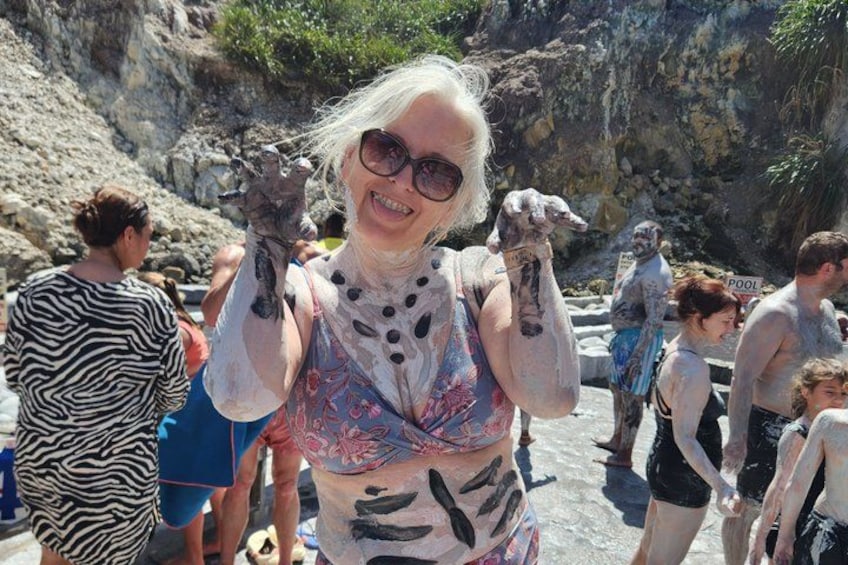 Una persona con una blusa estampada y un grupo de personas en un entorno natural rocoso. 3