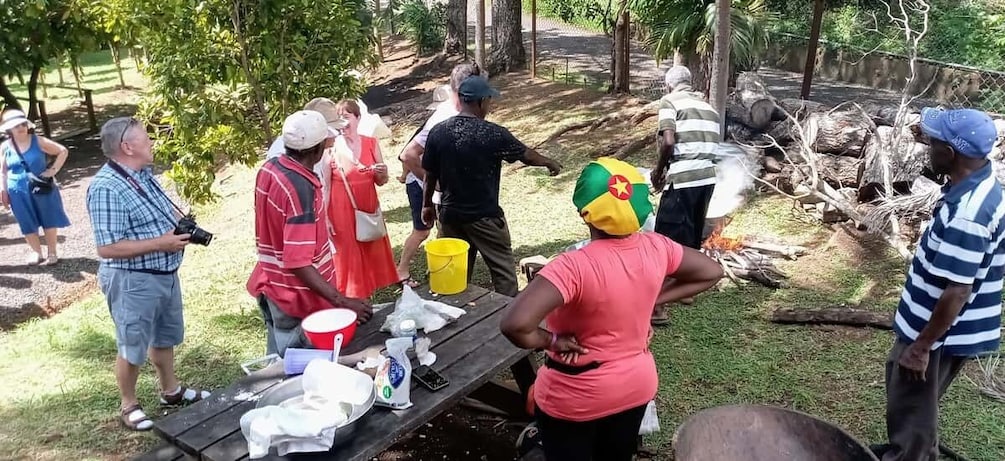 Un grupo de personas reunidas alrededor de una mesa de picnic al aire libre. 3