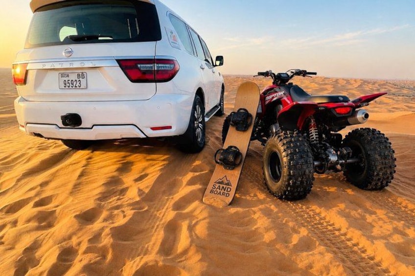 Un SUV bianco con una tavola da surf sulla sabbia e un quad rosso nel deserto. 3