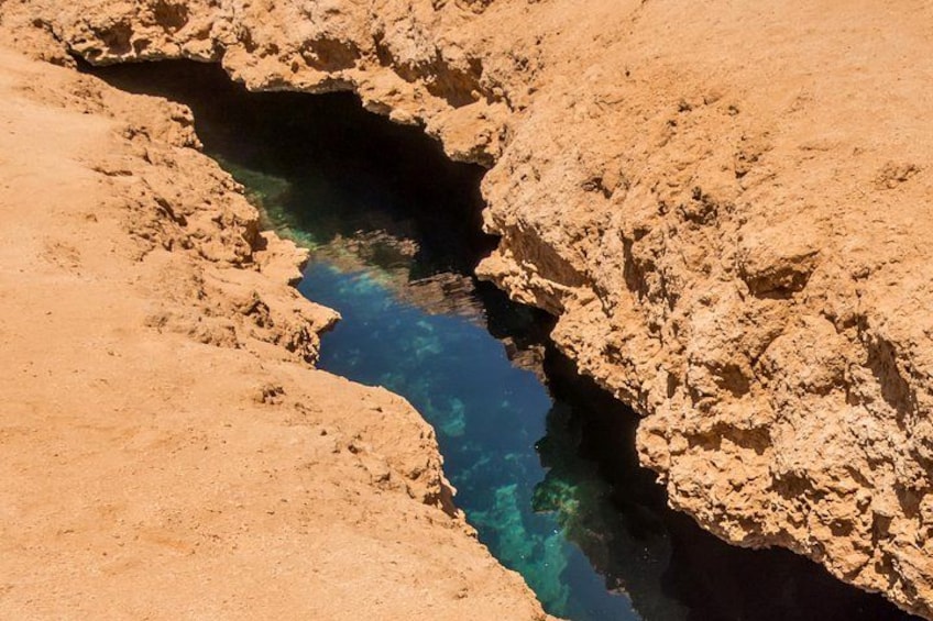 A narrow canyon with a clear blue water channel. 4