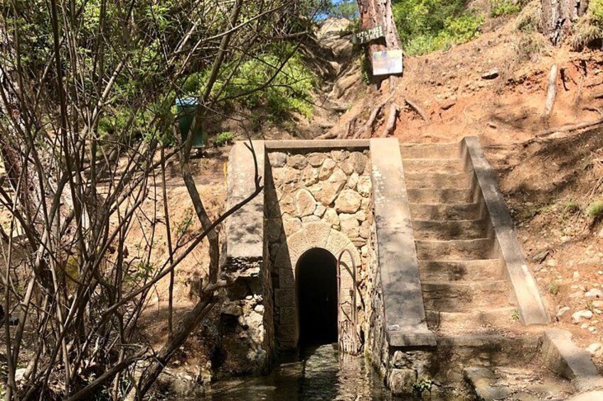Un escalier en pierre menant au sommet d’une colline, avec un petit pont de pierre enjambant un ruisseau. 2