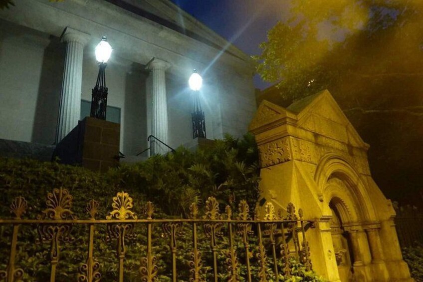 A building with columns and a statue, illuminated by street lamps. 2