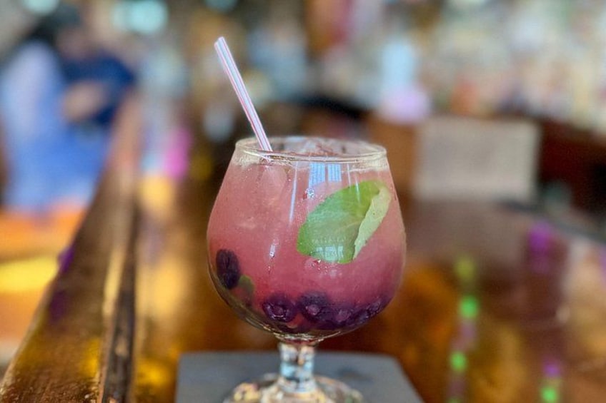Een glas mixdrank met rietje, versierd met een muntblaadje, op een bargedeelte. 3