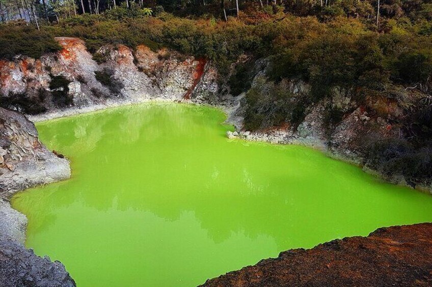 A green mineral pool surrounded by rocky terrain. 2
