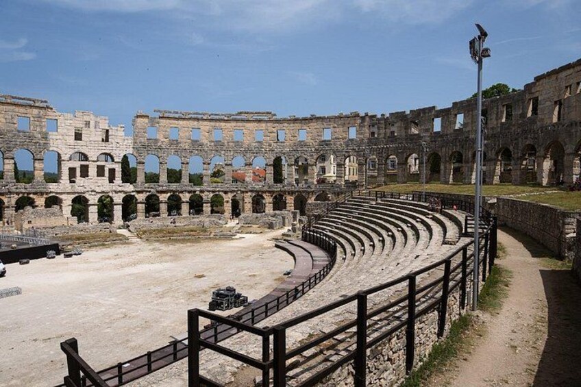 Un amphithéâtre antique doté de plusieurs niveaux de gradins et d’une scène centrale. 3