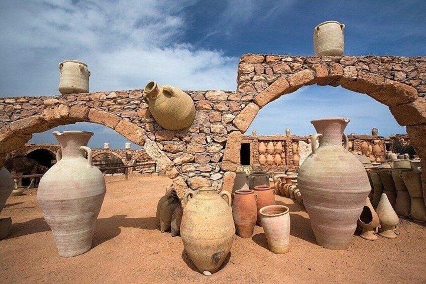 A collection of pottery under a stone archway. 2