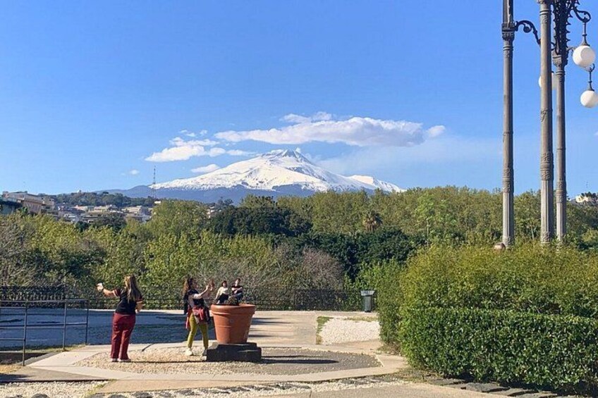 A group of people near a body of water with a mountain in the background. 3