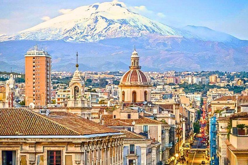 A cityscape with a prominent dome and a tall building, a snow-capped mountain in the background, and a river in the foreground. 5