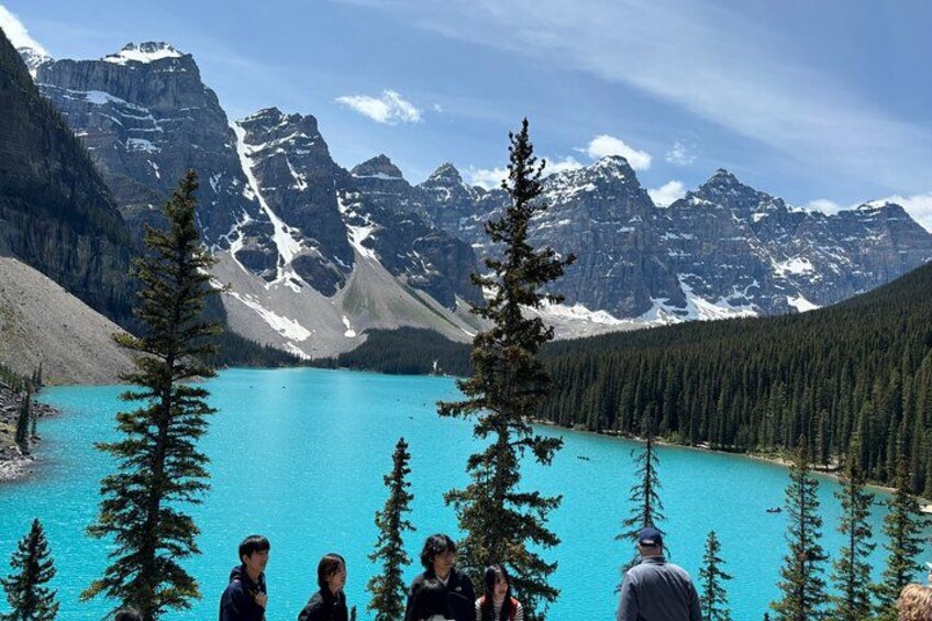 Un lago turchese circondato da montagne e pini. 1