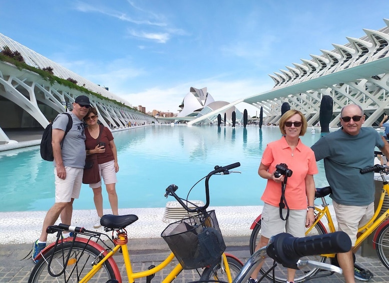 A group of people near a modern architectural structure with a pool. 1