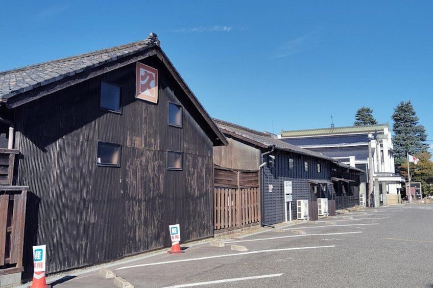 A street with old wooden buildings, a clear blue sky, and a few traffic cones. 4