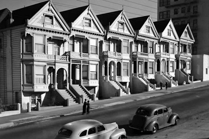 A row of Victorian-style houses with steep gabled roofs and ornate detailing. 5
