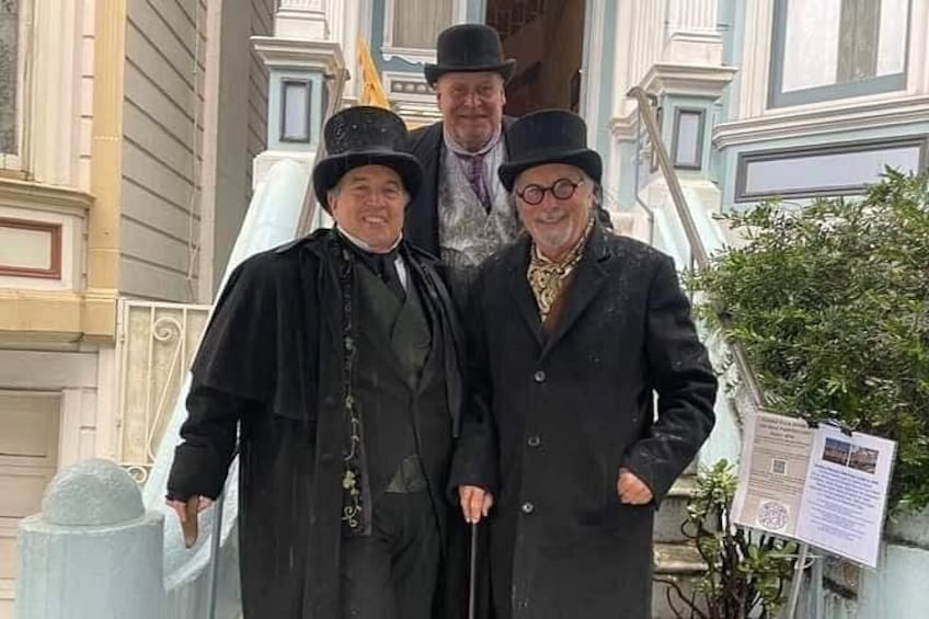 Three people standing in front of a building with ornate architecture. 4