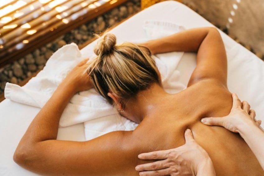Een persoon ontvangt een rugmassage op een witte massagetafel. 4