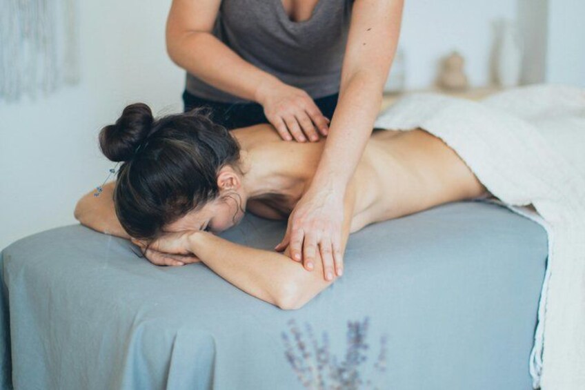 Iemand ontvangt een massage op een massagetafel. 3