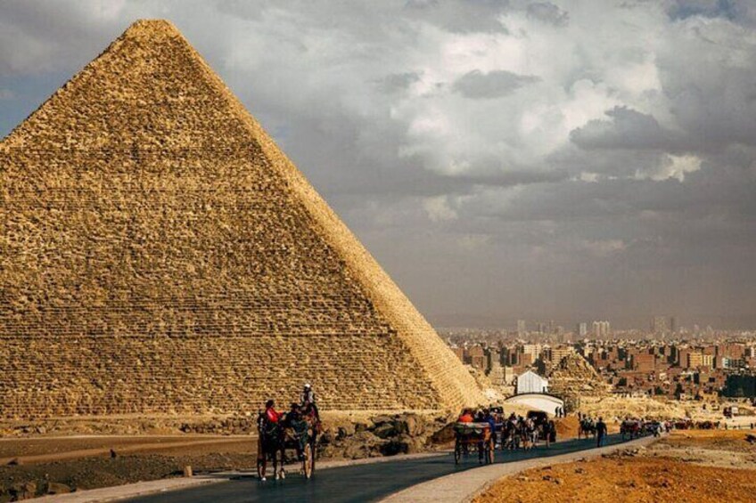 La Grande Pyramide de Gizeh, avec des touristes et des calèches au premier plan. 4
