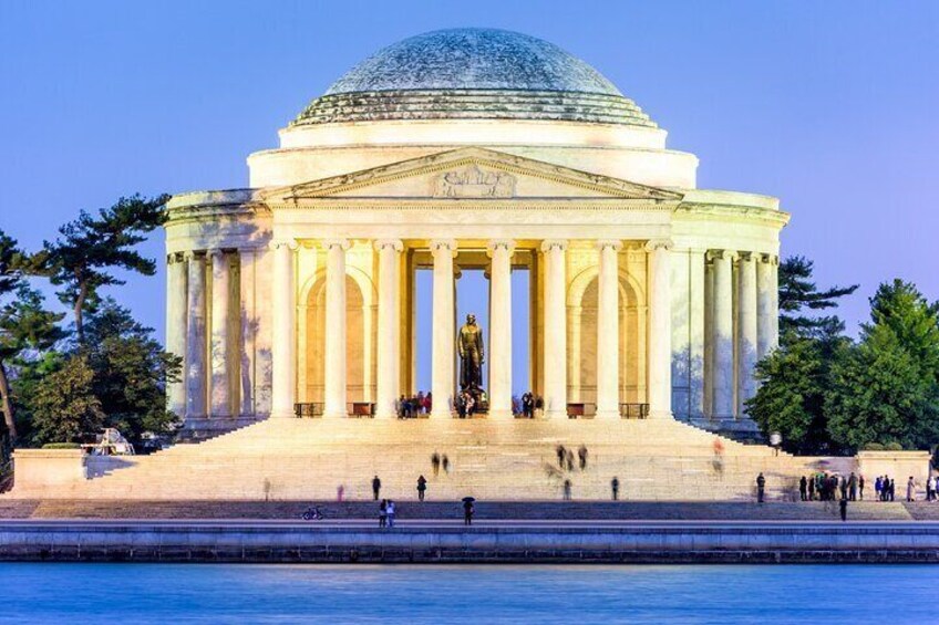 A neoclassical building with a large dome and columns, situated by a body of water. 2