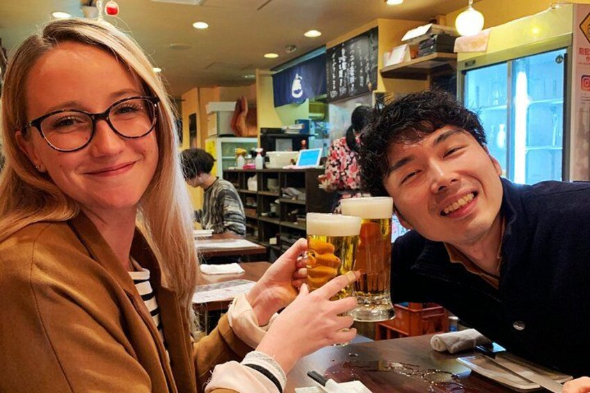 Deux personnes trinquent avec des verres de bière dans un restaurant. 3