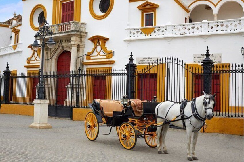 Une calèche tirée par des chevaux est garée devant un bâtiment aux murs jaunes et blancs et aux portes rouges. 2
