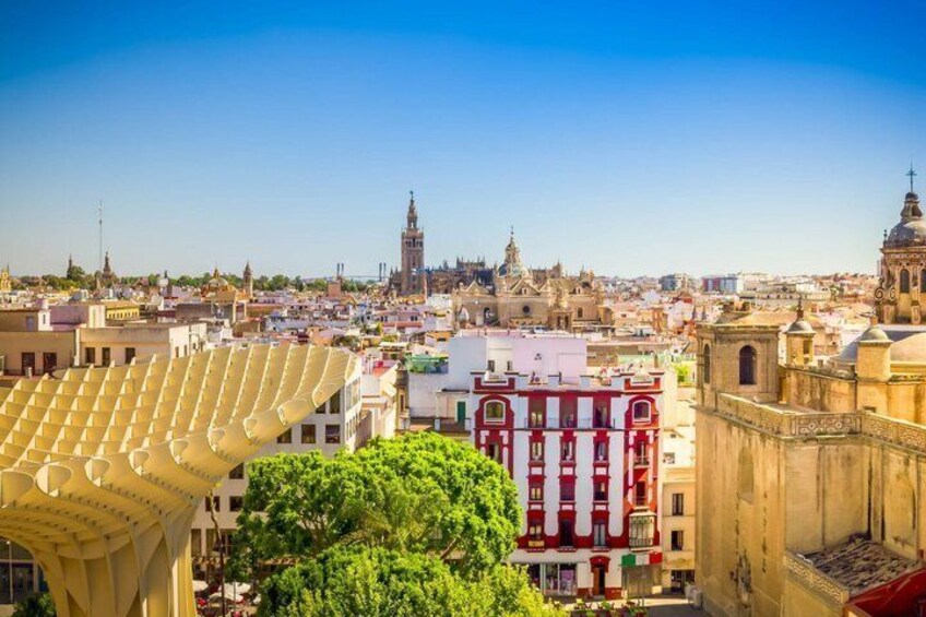 Une vue urbaine avec une tour de l’horloge bien visible, un bâtiment rouge aux ornements blancs et une structure jaune au premier plan. 3