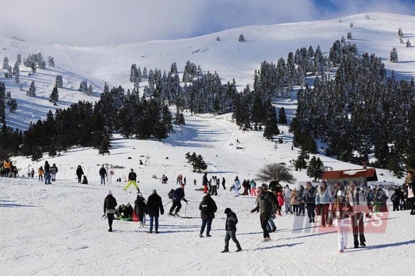 A snowy mountain slope with skiers and snowboarders. 2
