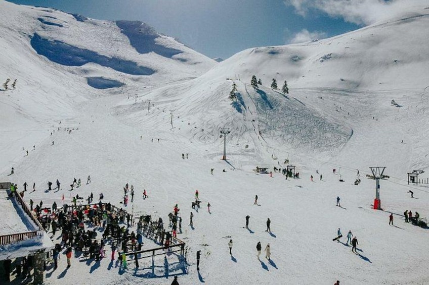 A snowy mountain with skiers and a ski lift. 1