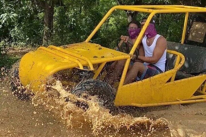 Un véhicule tout-terrain jaune traverse une zone inondée en soulevant des éclaboussures. 1