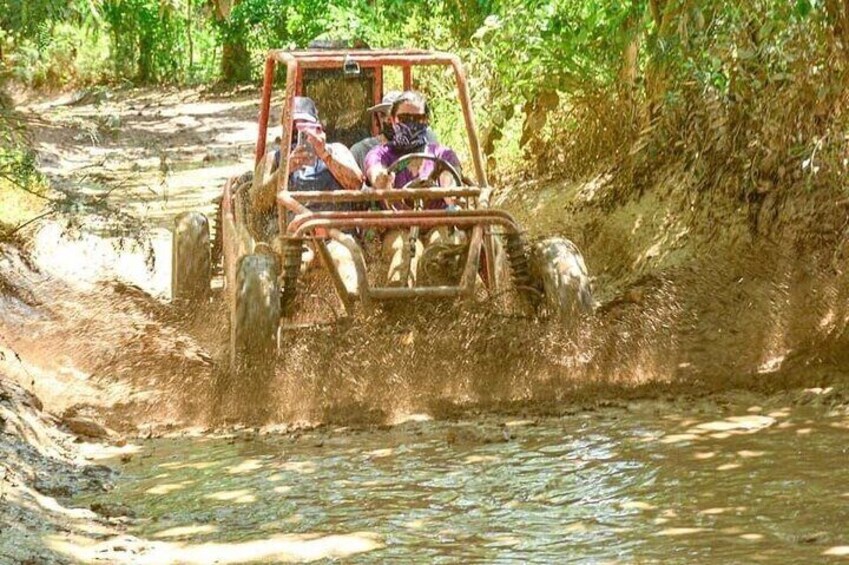 Un véhicule se déplaçant sur un terrain boueux, avec de l’eau de chaque côté. 5