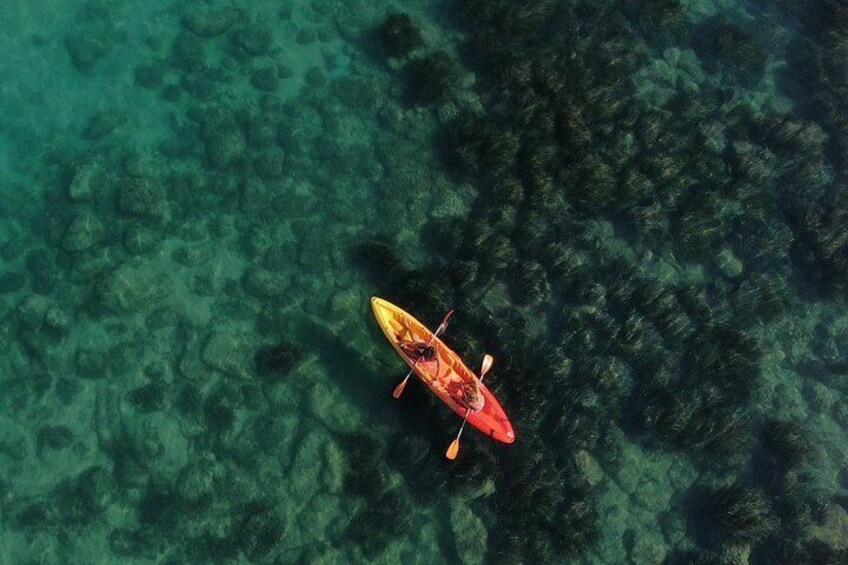 A red kayak on a clear, rocky underwater surface. 1