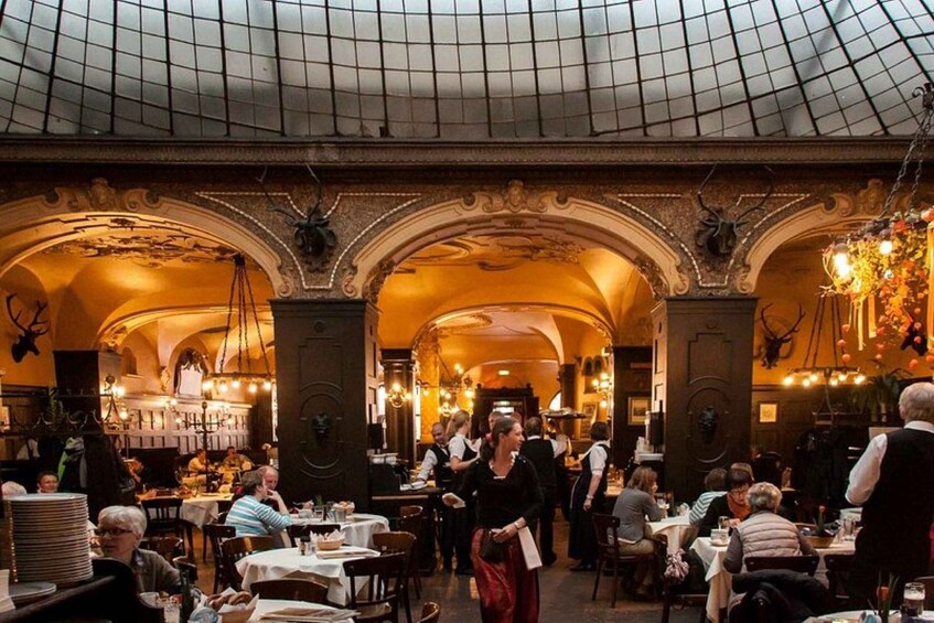 An indoor dining area with ornate arches and chandeliers. 1