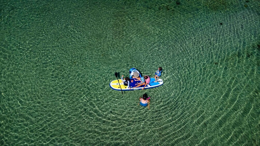 A person on a paddleboard in clear water. 5