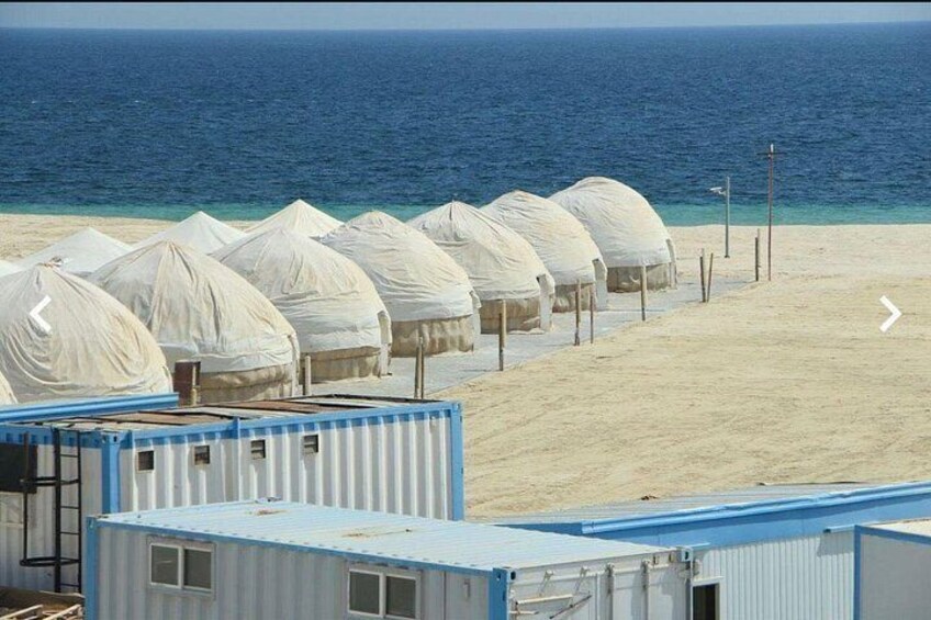 Una playa con yurtas y contenedores marítimos. 2