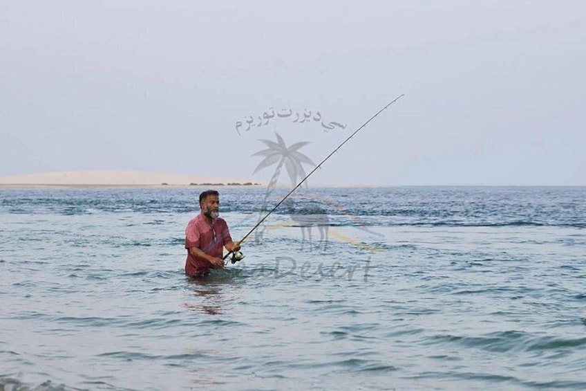 Una persona pescando en un cuerpo de agua con una caña de pescar. 5