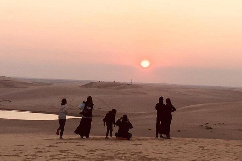 Un grupo de personas de pie en un paisaje desértico al atardecer. 4
