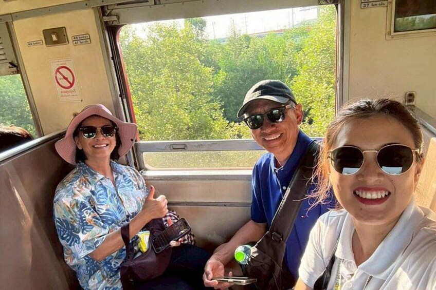 Three people seated inside a vehicle with a view of greenery outside. 4
