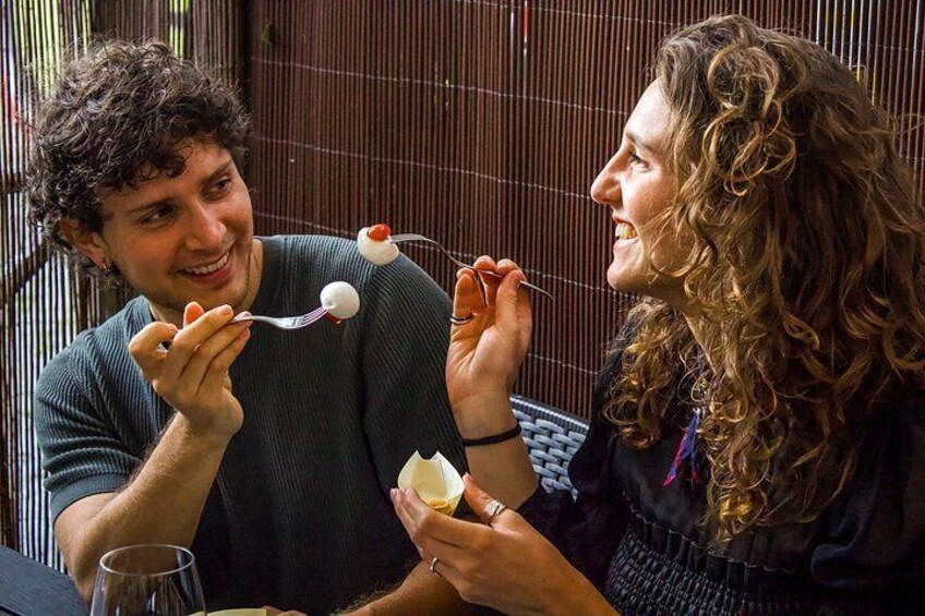 Deux personnes sont assises à une table, devant un verre de vin et une assiette de dessert. 3