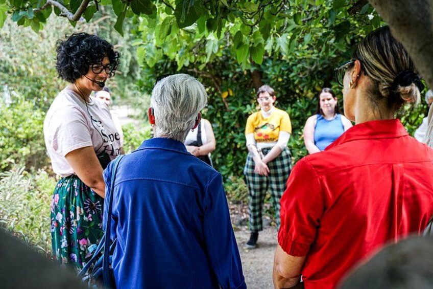 A group of people standing outdoors, engaged in a discussion. 3
