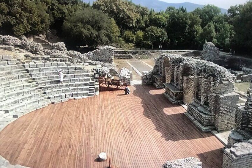 An ancient amphitheater with stone steps and a wooden stage. 4