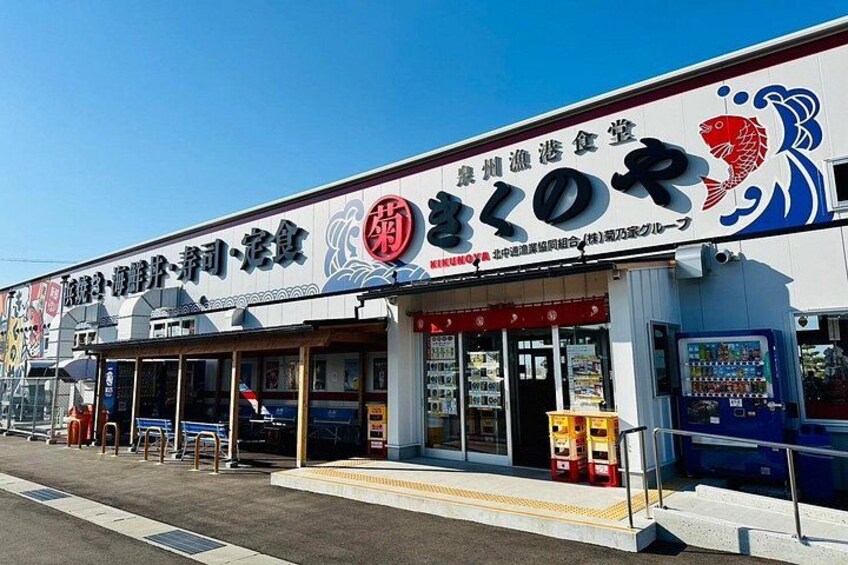 A commercial building with a signboard, a vending machine, and a wheelchair-accessible ramp. 2