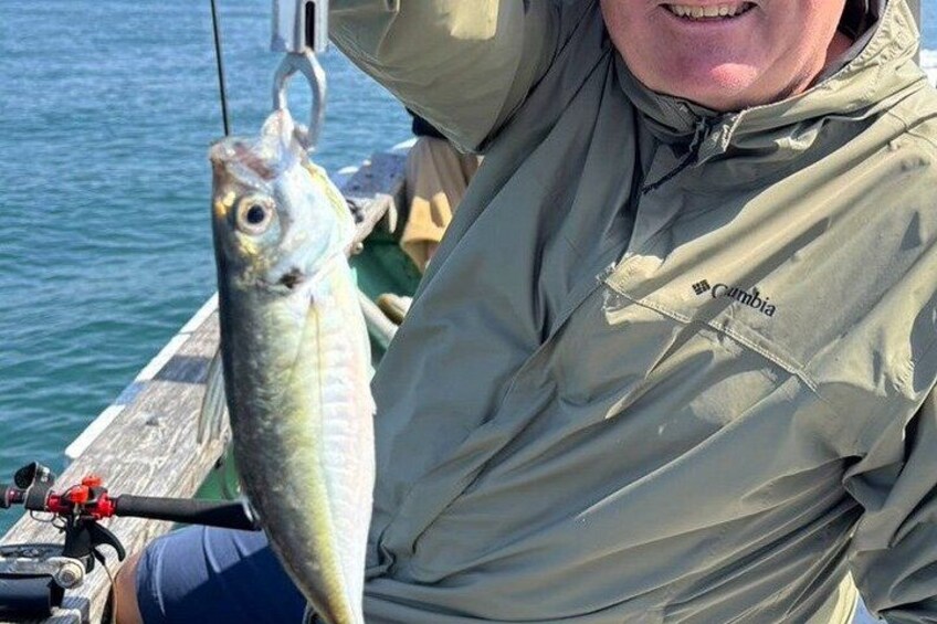 A person holding a fish on a boat. 3