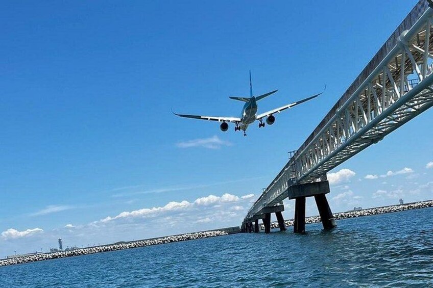 An airplane landing on a bridge over water. 3