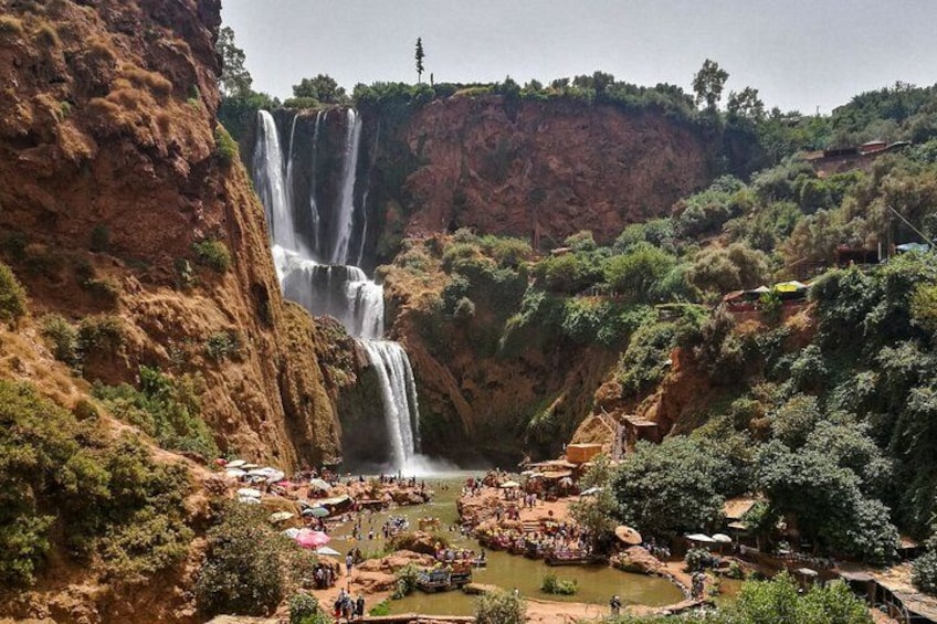 Una cascada se precipita en un río rodeado de exuberante vegetación y acantilados rocosos. 4