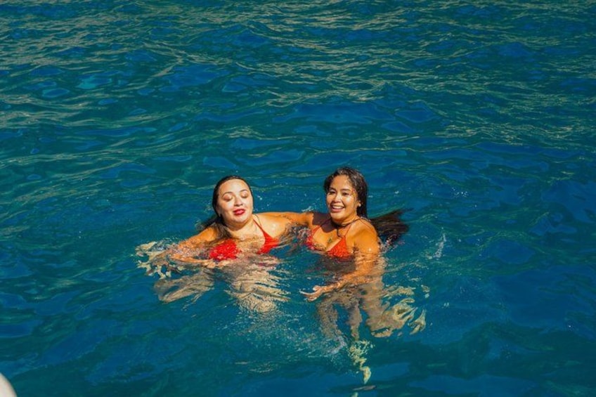 Two people swimming in a pool. 2
