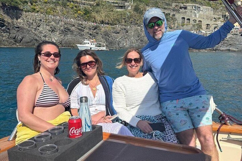 Eine Gruppe von Menschen auf einem Boot vor einer felsigen Küste. 3