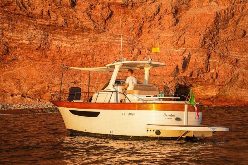 A boat named 'Mama' anchored near a rocky cliff. 2