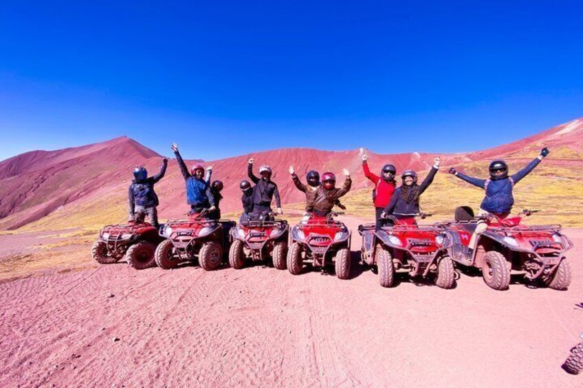 A group of people on ATVs in a desert landscape with mountains in the background. 4