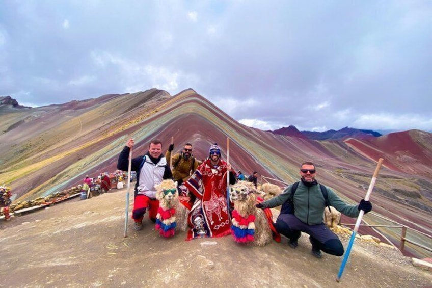 A group of people with llamas on a mountain ridge. 2