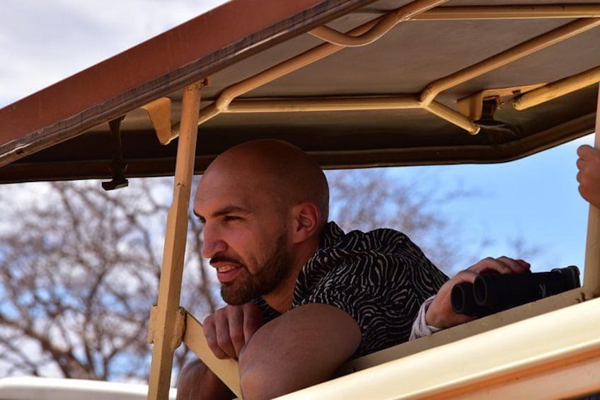 A person leaning out of a vehicle with a camera. 4