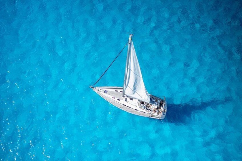 A sailboat on clear blue water. 1