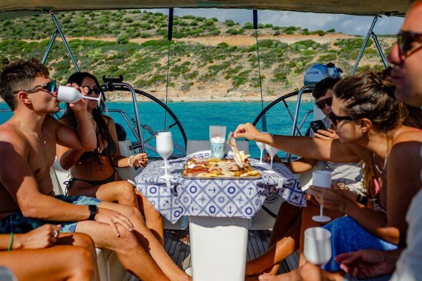 People dining on a boat with a table set for two, overlooking a beach. 3